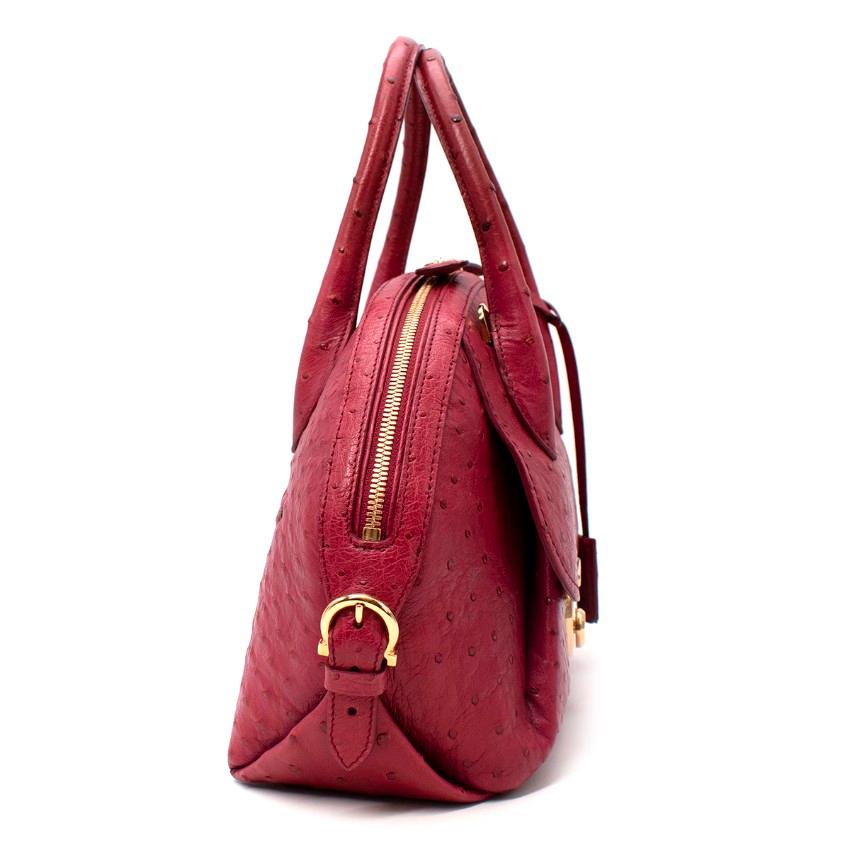 Salvatore Ferragamo Fiamma Wine-Red Ostrich Top Handle Bag
 

 - Ostrich Fiamma bag in wine-red hue with a mauve undertone
 - Removable, adjustable shoulders strap
 - Gold-tone hardware closure to the flap, top zip fastening, and rear zip pocket
 -