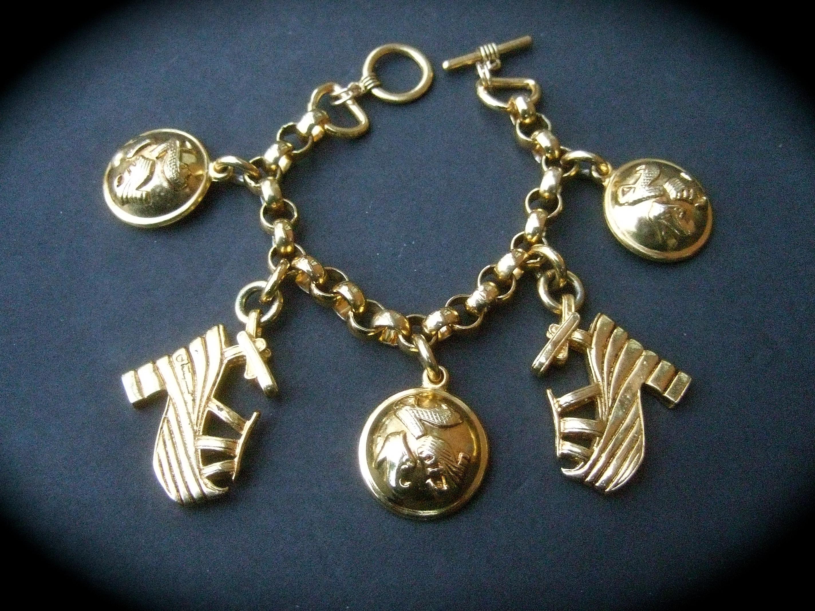 Salvatore Ferragamo Gilt metal shoe themed charm bracelet c 1990s
The stylish bracelet is adorned with a collection of large scale dangling charms
Two of the gilt metal charms are a pair of platform shoes which is a recurring theme in Ferragamo