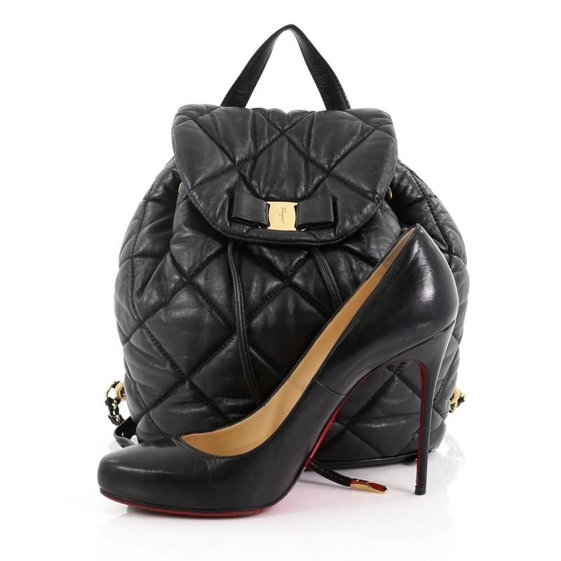 This Salvatore Ferragamo Giuliette Backpack Quilted Leather, crafted from black quilted leather, features dual adjustable chain straps with leather, signature logo engraved vara bow, and gold-tone hardware. Its hidden magnetic snap and drawstring