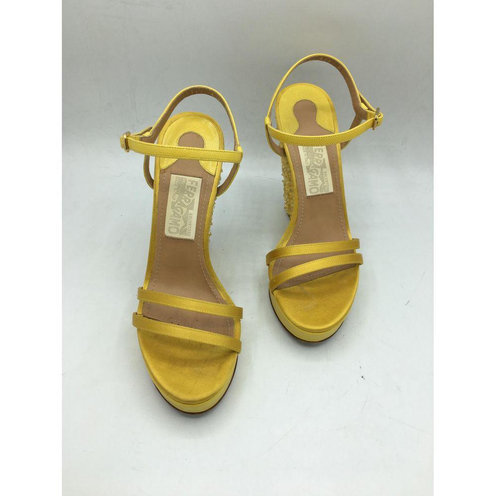 Salvatore Ferragamo Glitter Sandals in Yellow

Ferragamo sandal. In leather and sequins. 
Number 6 and a half which corresponds to a 37 it. 
The inner sole measures 24 cm and a half, the wedge 12 cm. 
With original dust and box . 
Excellent