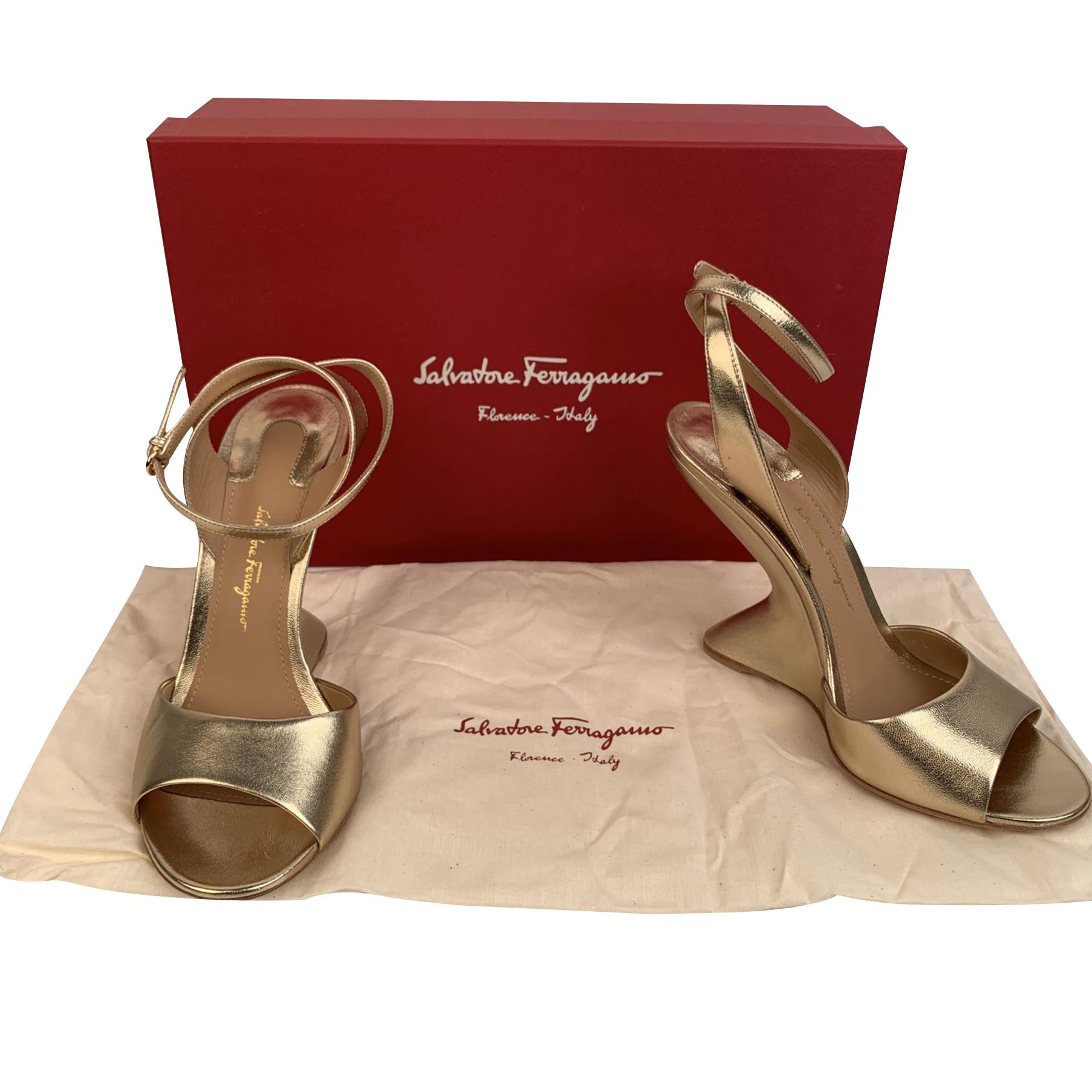 Elegant Salvatore Ferragamo 'Arsina 105' wedge sandals. Crafted in gold metal leather. They feature open toe, high sculpted wedge heel and ankle strap with adjustable buckle. Made in Italy. Heels Height: 4.1 inches - 10.5 cm. Size: US 7.5 C - EU 38