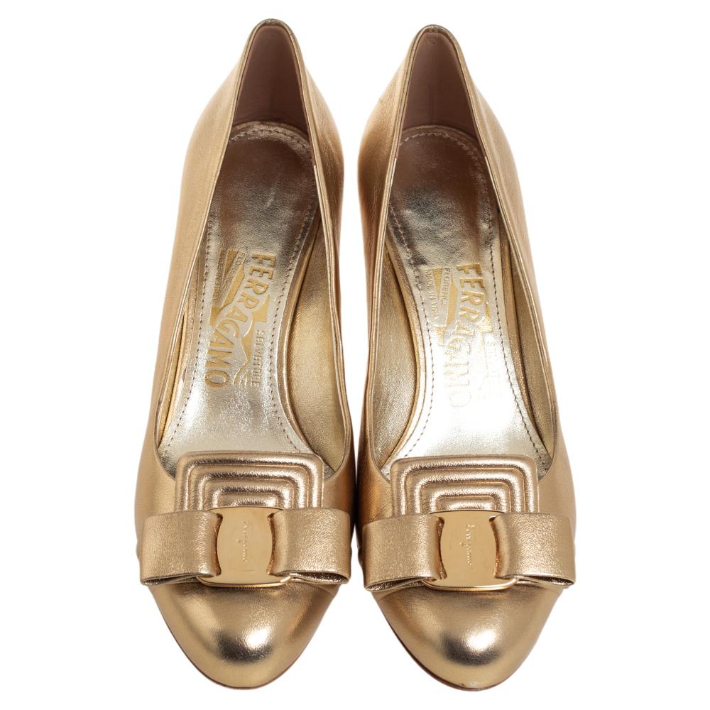 A feminine flair, sleek cuts, and a timeless appeal characterize these Salvatore Ferragamo pumps. Crafted from leather in a dazzling gold shade, they are designed with bows and raised on slender heels.

Includes: Info Booklet, Extra Heel Tip,