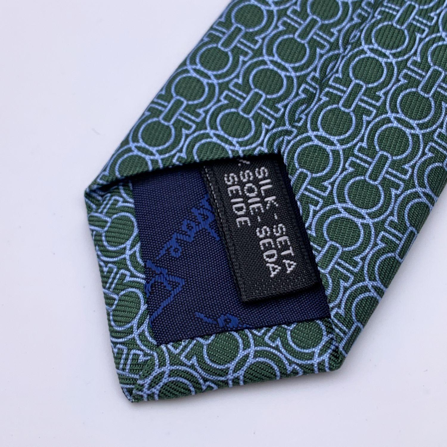 Salvatore Ferragamo 'Icona' men neck tie. Allover light blue Gancini pattern on dark green background. Composition: 100% Silk. Measurements: 60 x 3.1 inches - 152 x 8 cm. Made in Italy. Retail price was 155 Euros Details MATERIAL: Silk COLOR: Green