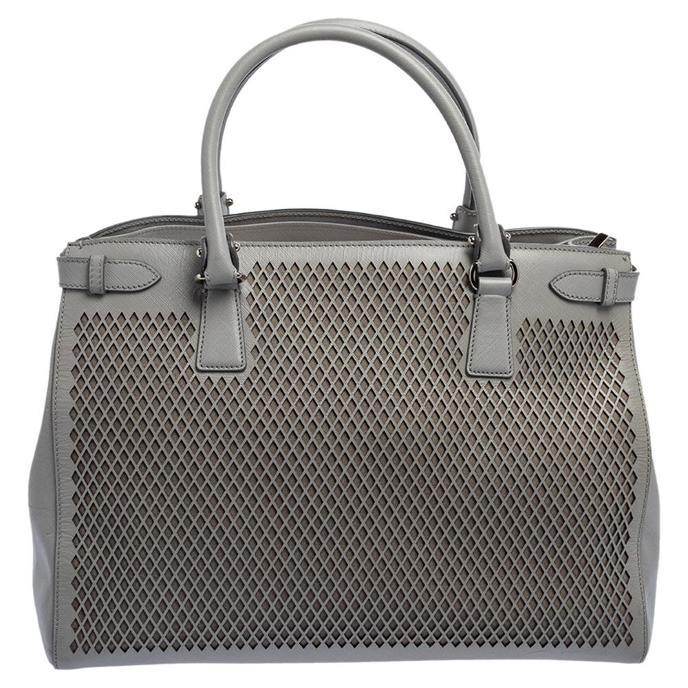 Diese elegante und geräumige Ledertasche wertet jeden Look auf. Diese Tasche hat ein stoffgefüttertes Inneres, das ideal für Ihre wichtigsten Dinge ist. Aus dem Hause Salvatore Ferragamo stammt diese graue, mit Lasercuts versehene Tote, die ein
