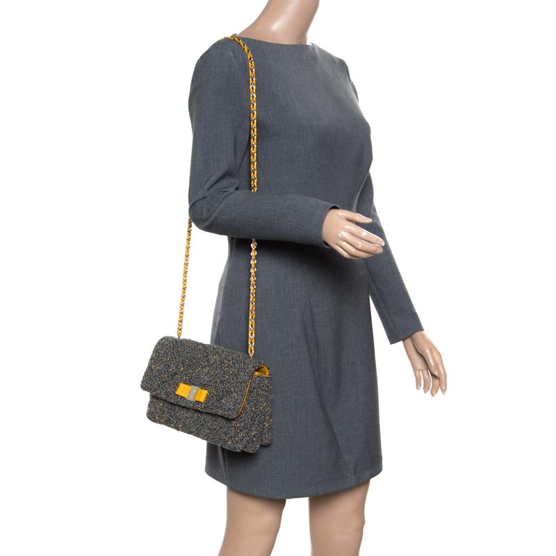 Extremely functional and stylish this Salvatore Ferragamo Gelly bag will be a top pick for the season. Efficient and well-designed, this tweed bag features a front flap decked with a contrasting Vara bow, a signature of the brand. It is all you need