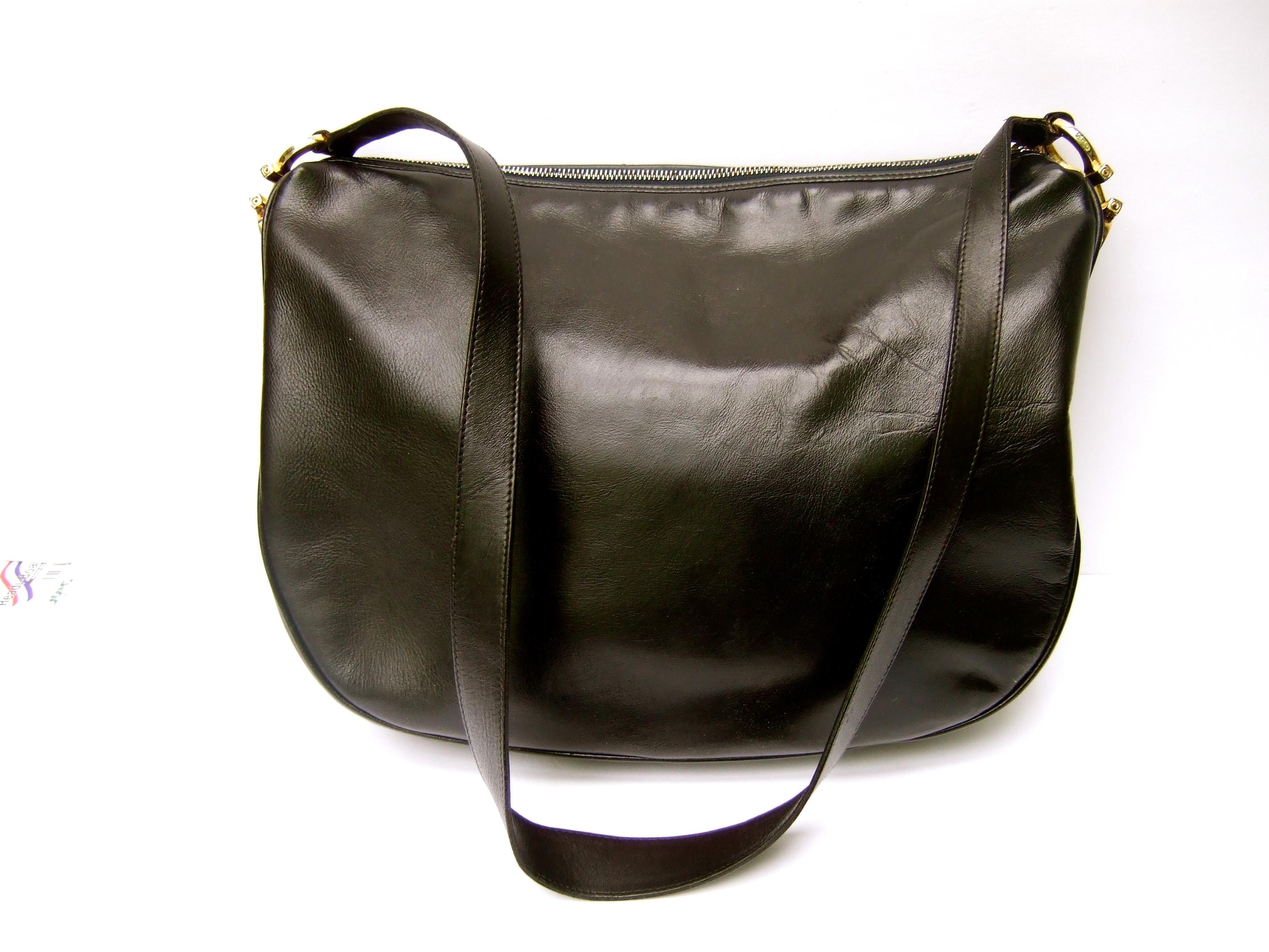 Salvatore Ferragamo Italian black leather shoulder bag c 1990s 
The Italian large scale roomy handbag is covered with smooth black 
leather with a slight sheen. Paired with sleek gilt metal hardware
inscribed Ferragamo 

The handbag zippers across