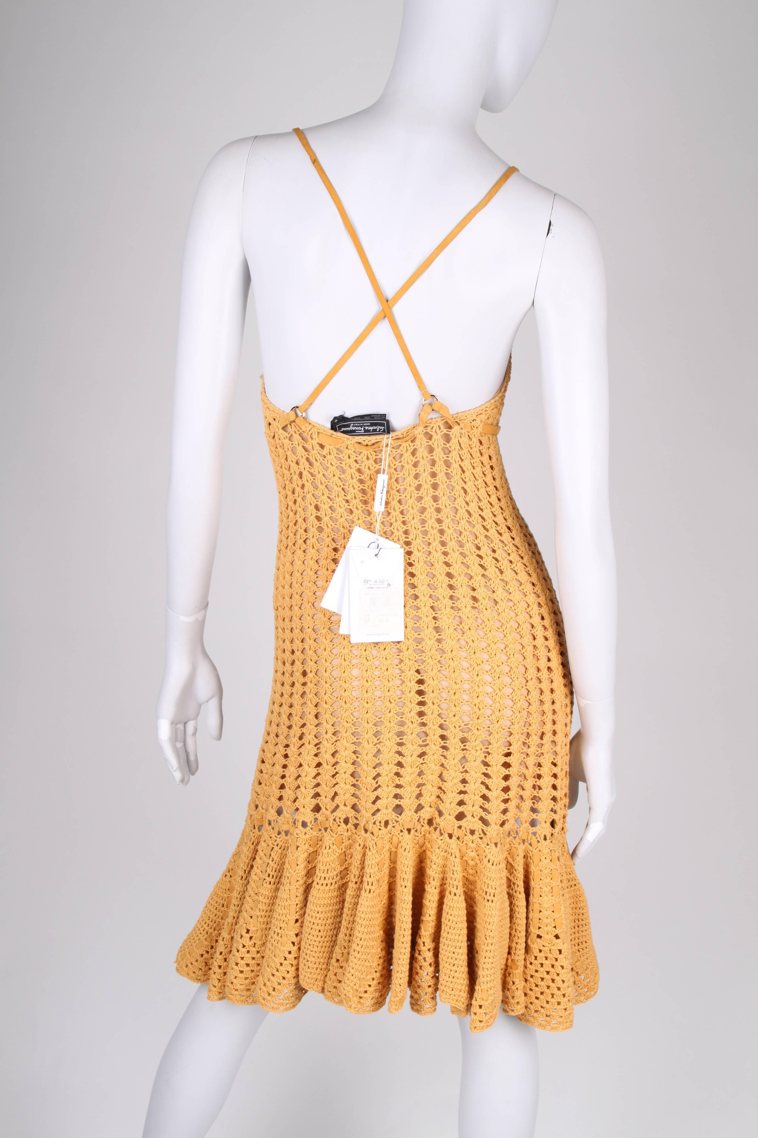 Fancy dress by Salvatore Ferragamo with leather detailing in a warm mustard yellow color.

The dress has narrow leather shoulder straps, a leather waist belt and is fully lined with skintone fabric. The knitted material is stretching, so there is no