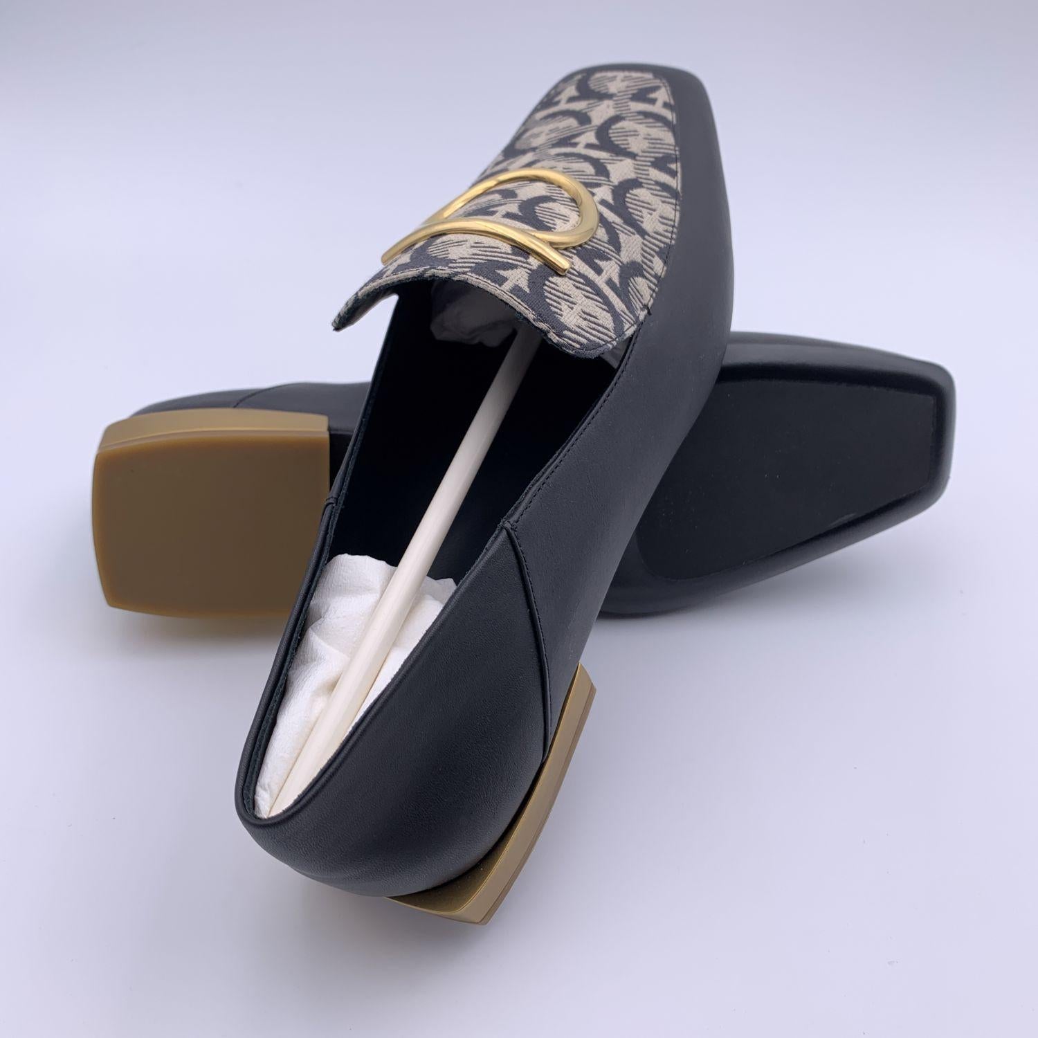 Schöne Salvatore Ferragamo 'Lana T 1' Mokassins Loafers Schuhe. Gefertigt aus schwarzem Leder. Sie haben einen Stoffeinsatz oben mit Gancini-Logo-Muster, große Gancino-Details aus goldenem Metall, eine quadratische Schuhspitze und sind zum