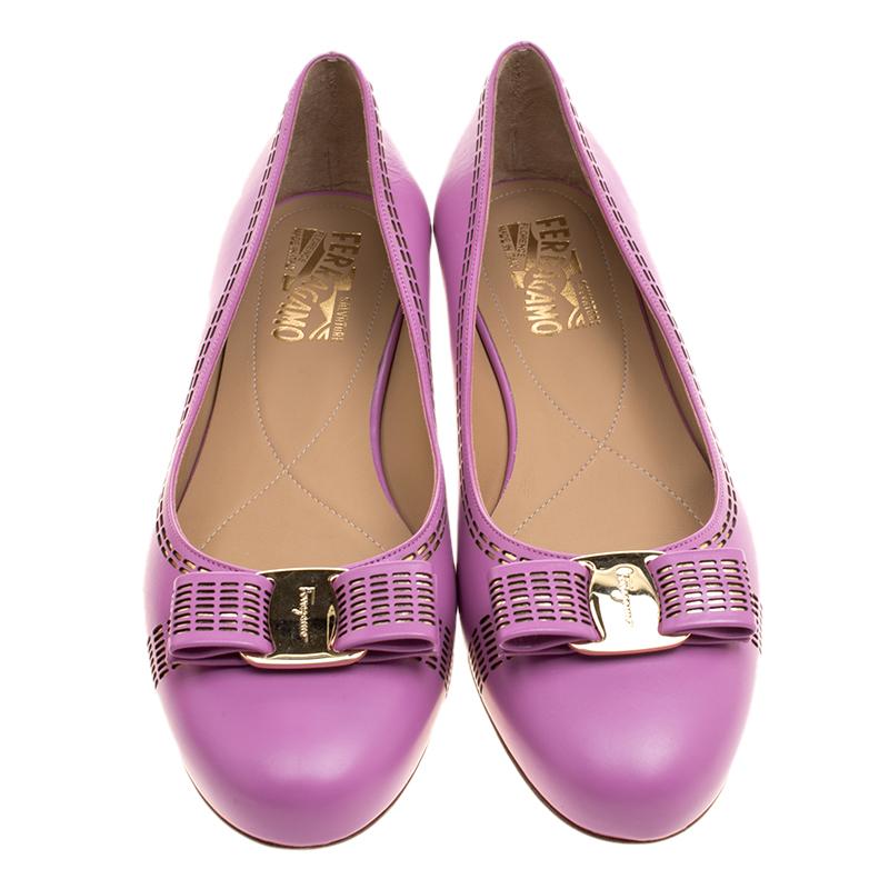 Step out with elegance in these dreamy purple ballet flats from the house of Salvatore Ferragamo. Crafted from leather, they feature cutouts with metallic leather inlay, comfortable insoles, and their signature Vara bows perched on the