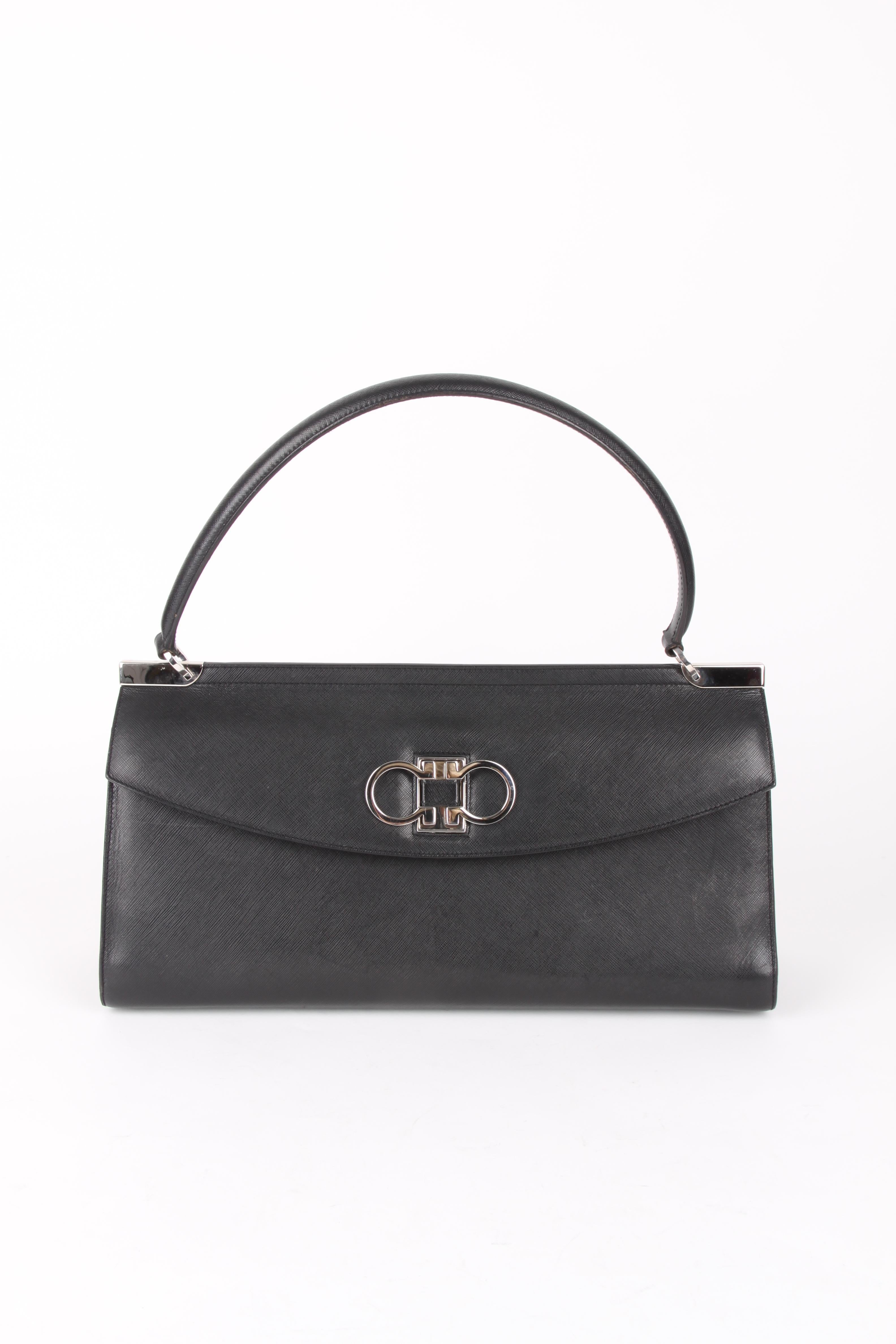 Salvatore Ferragamo Logo Plaque Leather Clutch Handbag.

The definition of Italian luxury, Salvatore Ferragamo prides itself on a seamless blend of high-quality materials, impeccable craftsmanship and a timeless design vision. This black leather