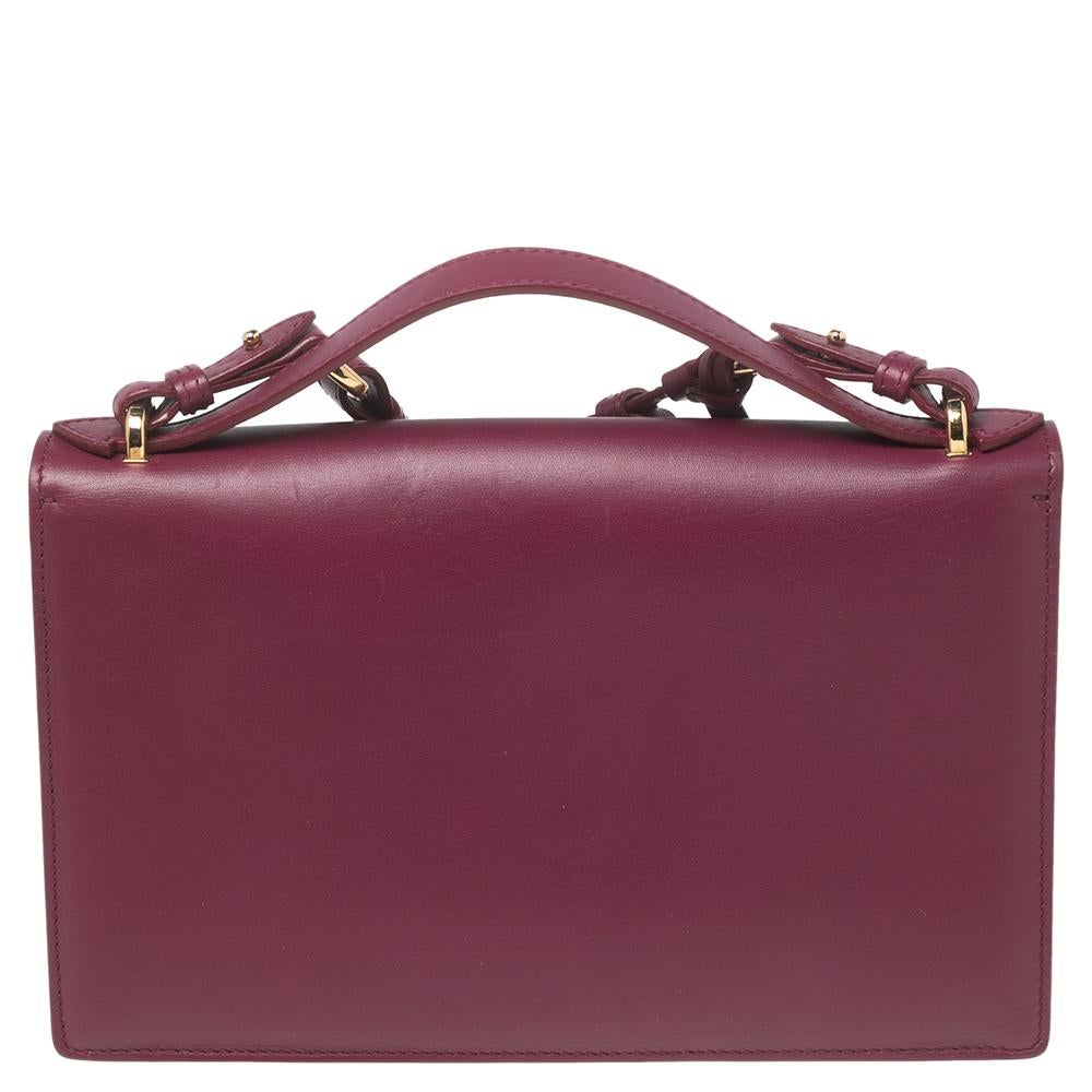 This magenta bag by Salvatore Ferragamo is a fabulous pick for both formal and informal occasions. It is made from quality leather and features a lined interior, a top handle, a shoulder strap, and a gold-tone Gancio lock on the front