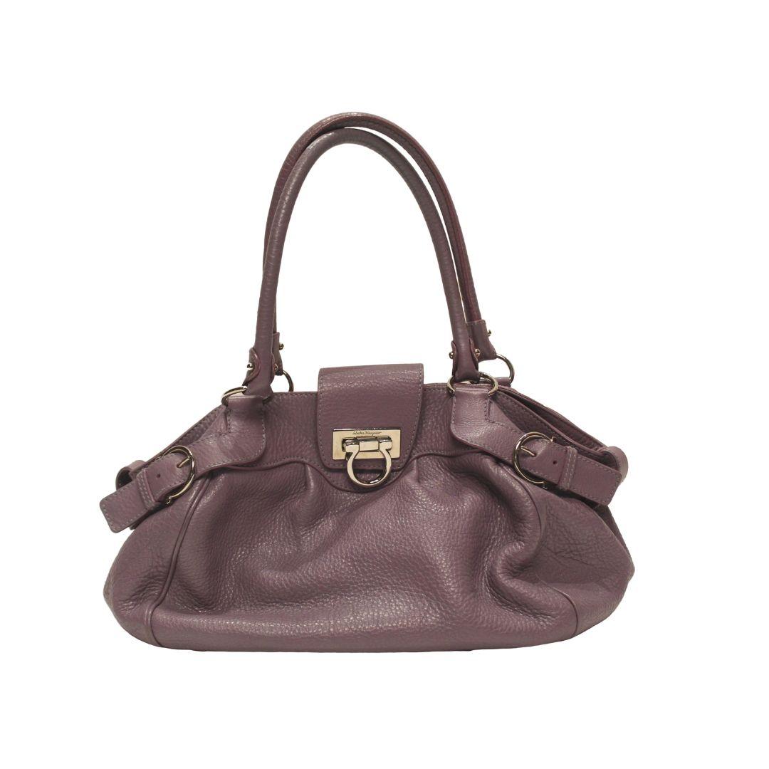 Gorgeous Salvatore Ferragamo Marisa shoulder bag in gorgeous violet leather with dual rolled shoulder straps and Gancio flip lock closure in silver toned hardware.

This beautiful bag features a SALVATORE monogram printed interior lining with inner