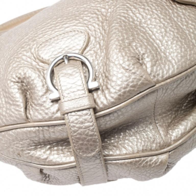 This magnificent bag from Salvatore Ferragamo is all that you need to instantly uplift your look. Crafted in Italy, this bag delivers sophistication and style. It is made of quality leather and comes in a lovely shade of metallic gold. This hobo bag