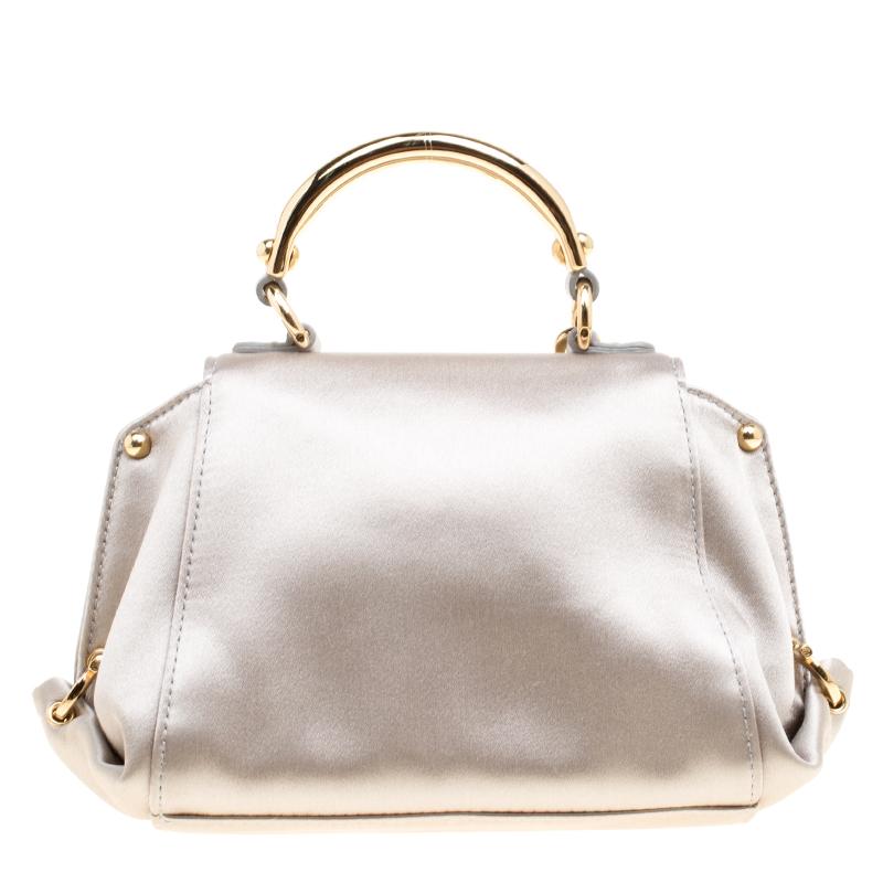 Carry this gorgeous Salvatore Ferragamo creation wherever you go and make people drool. Meticulously crafted from metallic grey satin, this bag has been styled with a top handle, a removable shoulder strap and a leather interior to hold your