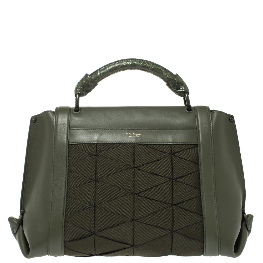 Carry this gorgeous Salvatore Ferragamo creation wherever you go and make people drool. Meticulously crafted in Italy and made from quality fabric & leather, this Sofia satchel comes in a lovely shade of military green. It has been styled with a top