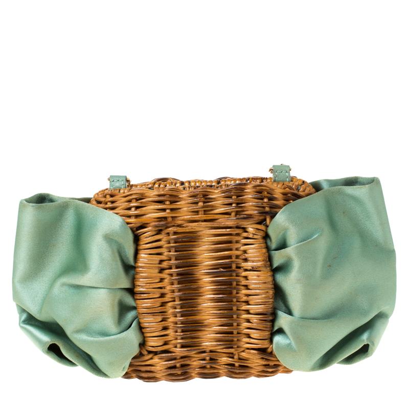 Made in Italy, and blooming with beauty is this beautiful chain clutch by Salvatore Ferragamo. It is made from woven rattan and styled with mint green satin in a bow design. It also features a gold-tone chain and a top lock that opens to a satin