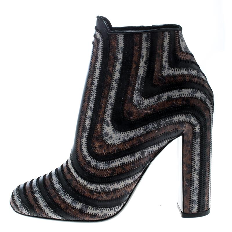 Salvatore Ferragamo brings you this pair of finely crafted leather boots that are absolutely stunning to look at. They are covered in different colours of leather in zig zag stitches and balanced on 12 cm block heels. You will love owning