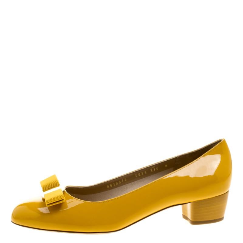 These stunning Salvatore Ferragamo Vara pumps are the perfect sleek and chic pair of footwear for those casual and festive occasions. Crafted in a bright yellow patent leather, these shoes flaunt a mid size block heel that is extremely comfortable