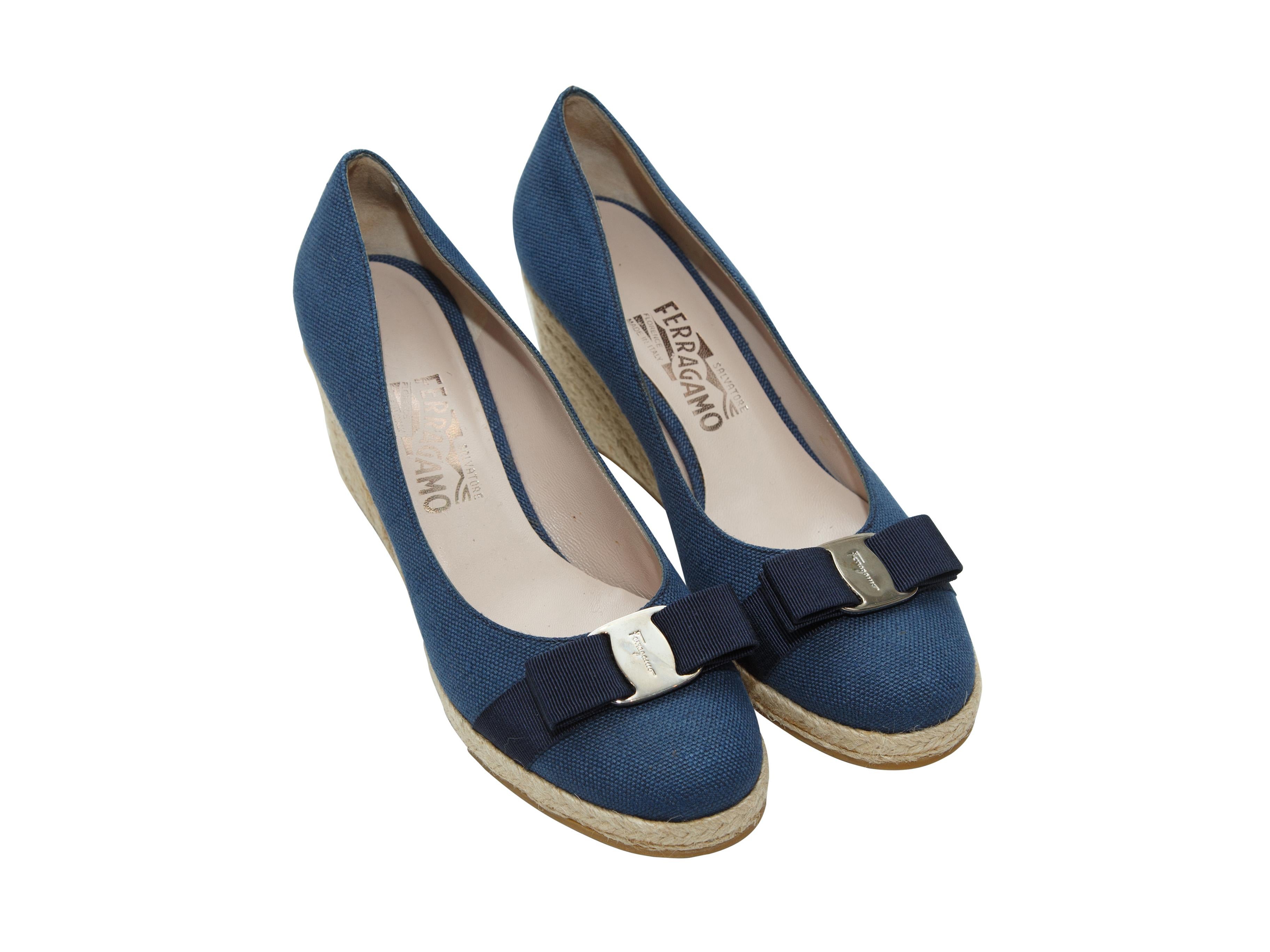 Product details: Navy blue canvas round-toe wedges by Salvatore Ferragamo. Raffia trim at heels. Bow accents at tops. 3