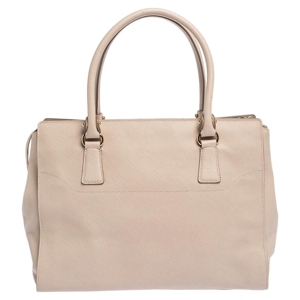 Finely crafted from quality leather, and shining with beauty is this beautiful tote by Salvatore Ferragamo. It comes with a great shape and gold-tone hardware, the Gancio motif in the front adds interest and the spacious fabric compartment can store