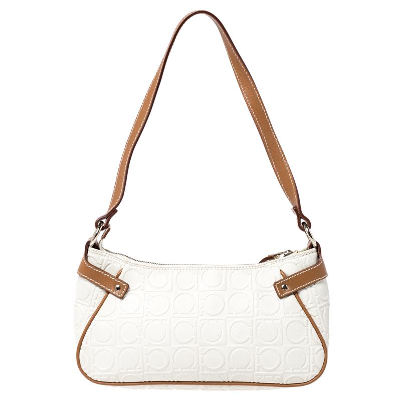 The excellent craftsmanship of this Salvatore Ferragamo bag ensures a brilliant finish and a rich appeal. This Gancini-embossed leather bag features a canvas interior and a single shoulder handle. A piece like this off-white bag will be your go-to