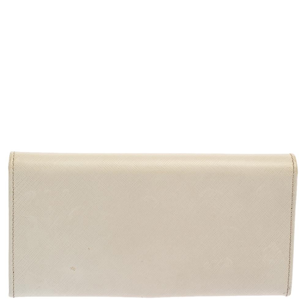 Crafted from leather, this continental wallet from Salvatore Ferragamo carries the signature Gancini motif on the front flap and an off-white hue. The flap opens to a functional interior equipped with multiple slots and a zipped compartment to carry