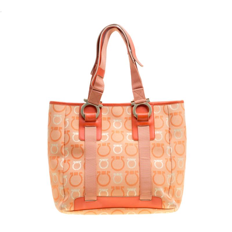 Made from orange -coloured canvas, this stylish tote from Salvatore Ferragamo is a stunner in every sense. Featuring a spacious interior with slip and zip pockets, this one will easily stow your basics and more. It features the signature Gancini