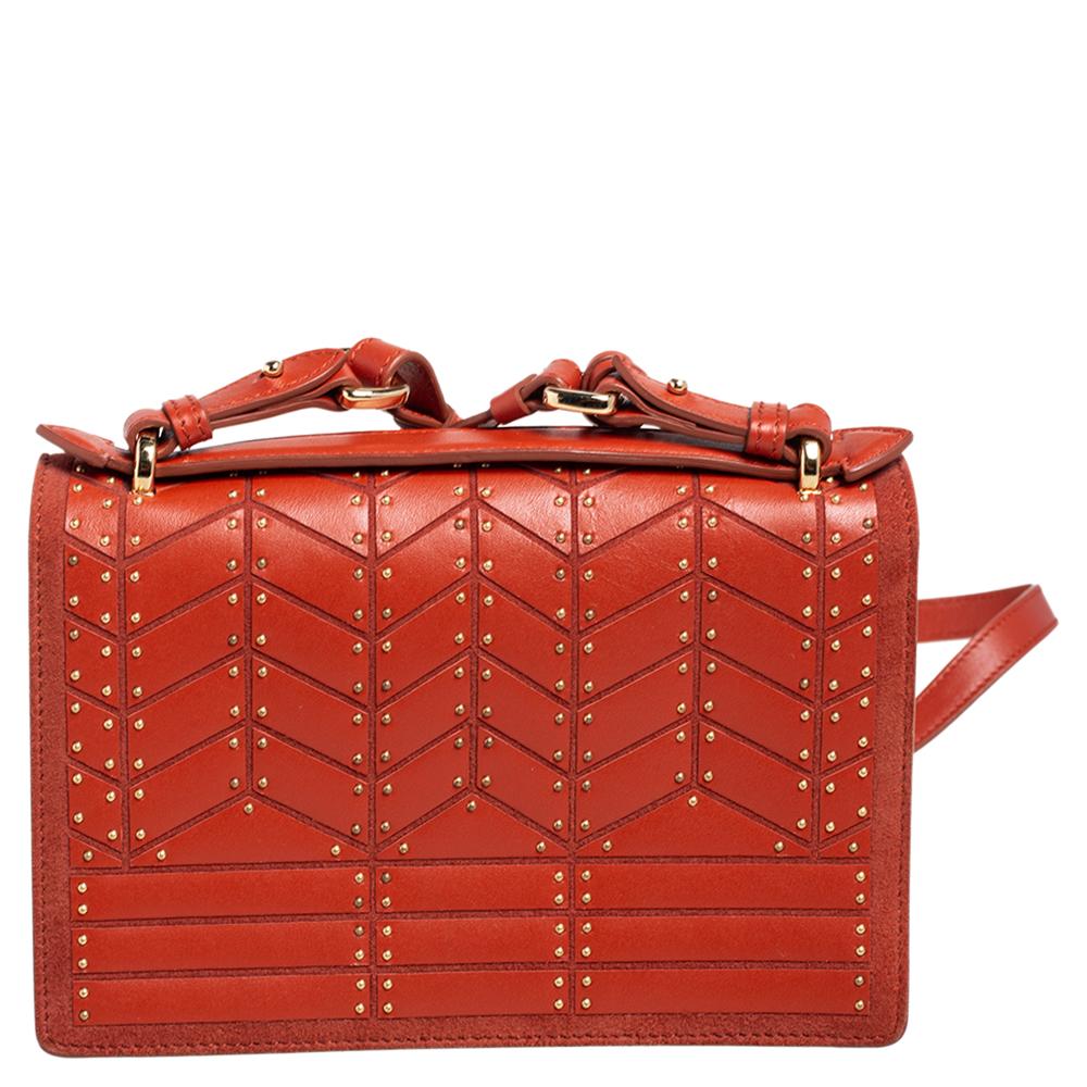 How gorgeous is this Aileen bag from Salvatore Ferragamo! It carries an outstanding boxy design and a studded leather & suede exterior in a striking orange hue. The signature lock on the flap secures a well-sized interior. The fresh look of the bag,