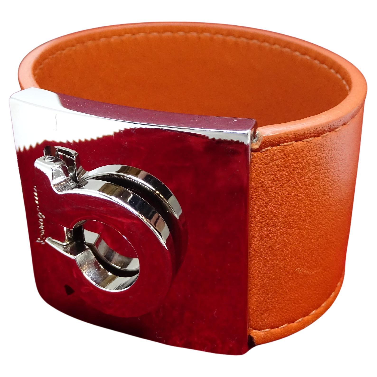 Asombrosa pulsera de cuero naranja con cierre de metal plateado grabado con la firma Ferragamo en el icónico 