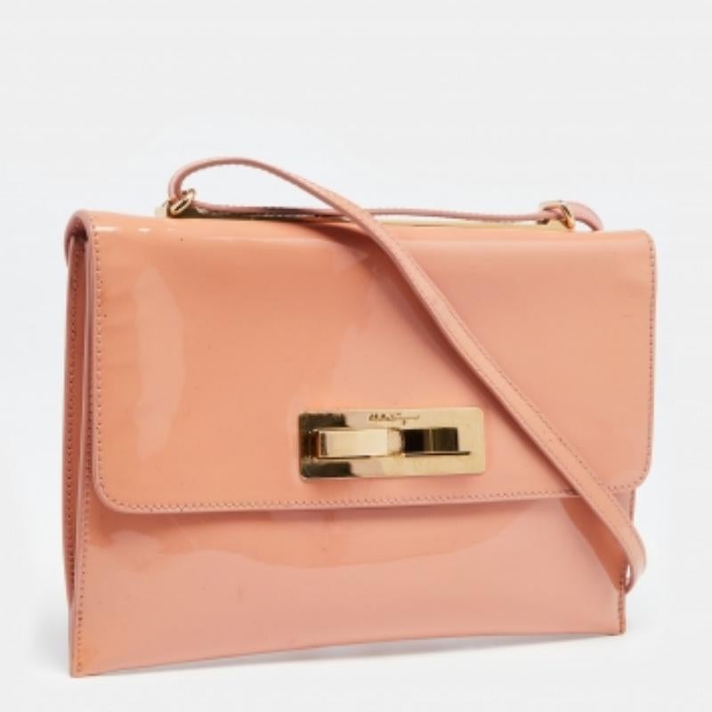 Diese Designer-Umhängetasche von Salvatore Ferragamo ist aus pfirsichfarbenem Lackleder gefertigt. Die Tasche hat einen Überschlag mit Schleife, einen Schulterriemen und ein ledergefüttertes Inneres. Diese Kreation lässt sich leicht an jedem Tag