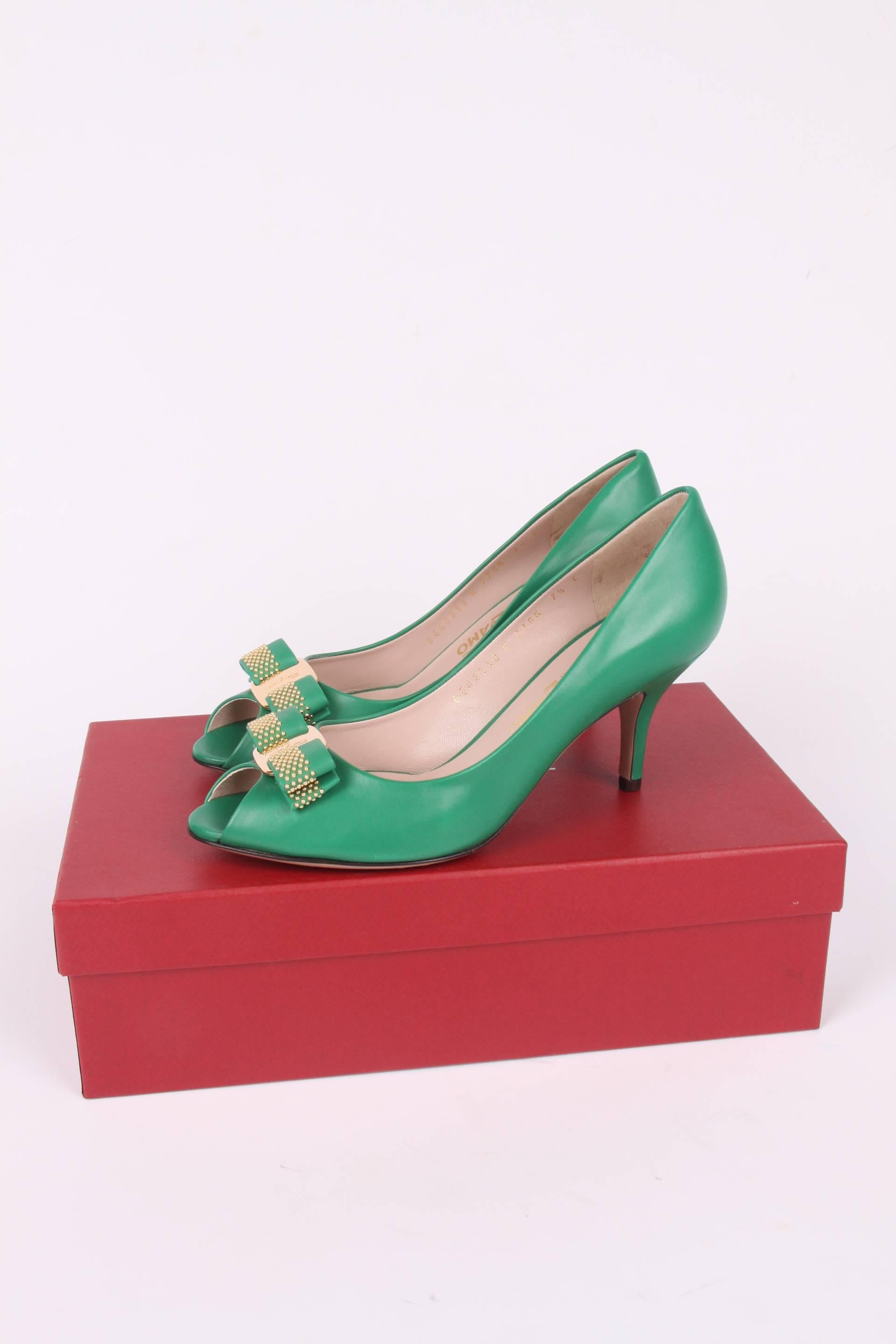 Cheerful pumps by Salvatore Ferragamo crafted in green leather.  

A peep-toe with a bow and a shiny gold-tone metal plaque with embossing of a Ferragamo logo. Leather outsole and a heel that measures 8 centimeters. Leather insole. 

New and never