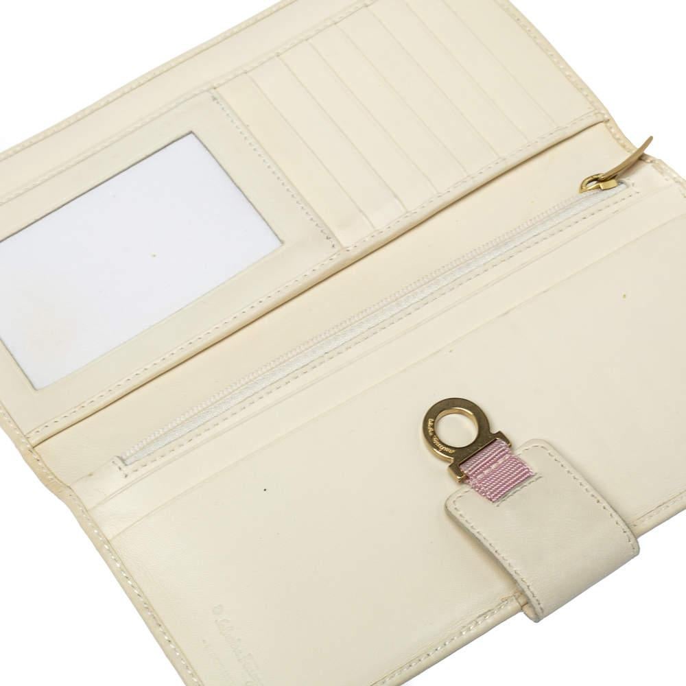 This stylish pink & cream creation from Salvatore Ferragamo is undoubtedly a fashionista's choice! Crafted in high-quality Gancini canvas and leather, this wallet features a flap with the brand logo. It is complete with multiple slots and enough