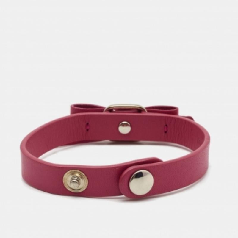 Aggiungi un tocco di stile femminile al tuo look con questo bracciale di Salvatore Ferragamo. Questo braccialetto è realizzato in pelle rosa e minuteria dorata. Presenta il caratteristico fiocco Vara sul davanti e una chiusura con bottoni a