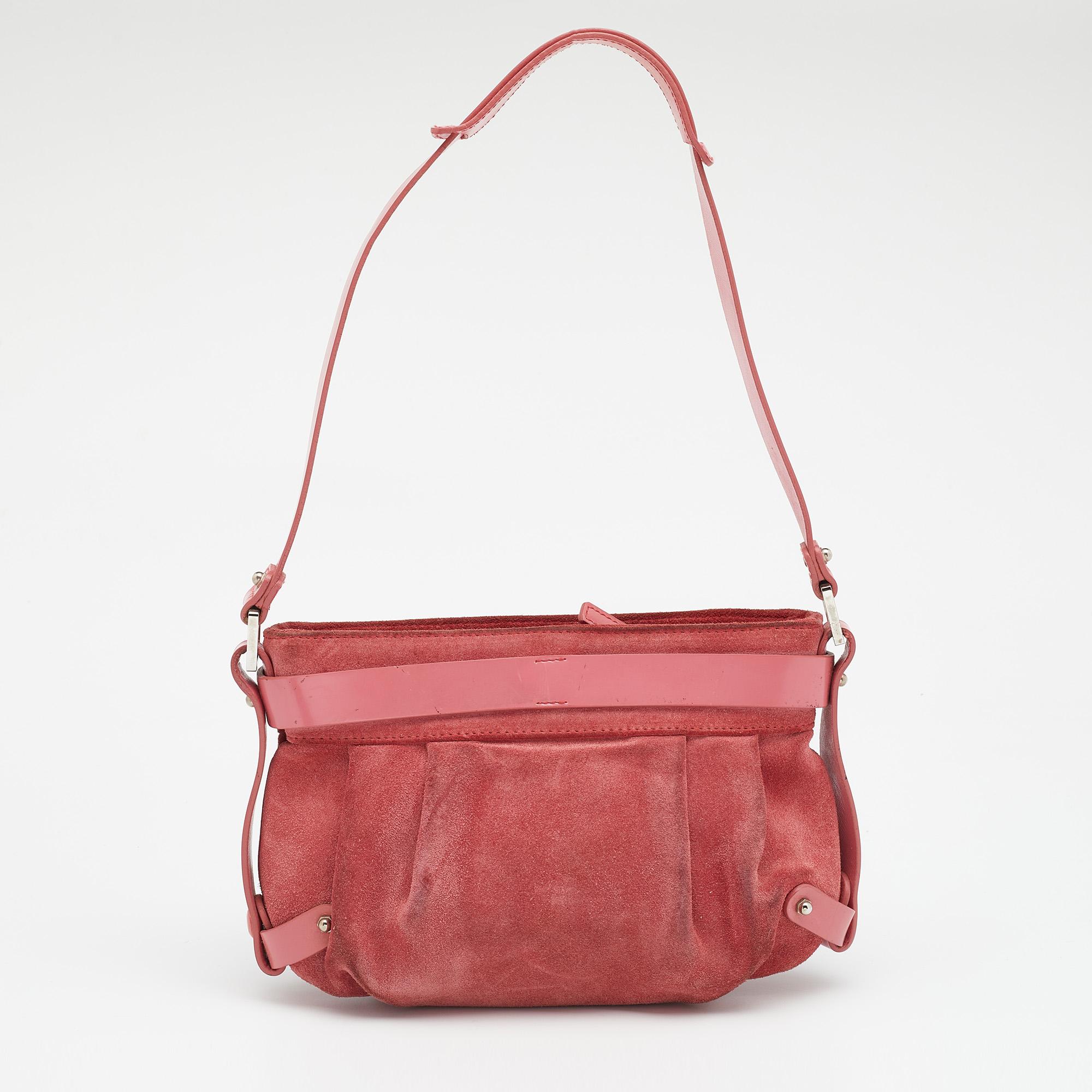 This shoulder bag from Salvatore Ferragamo has been designed to be a worthy style companion! Crafted from suede and leather, the pretty pink bag features the brand's famous Gancio detail on the front. It is equipped with a single handle and a