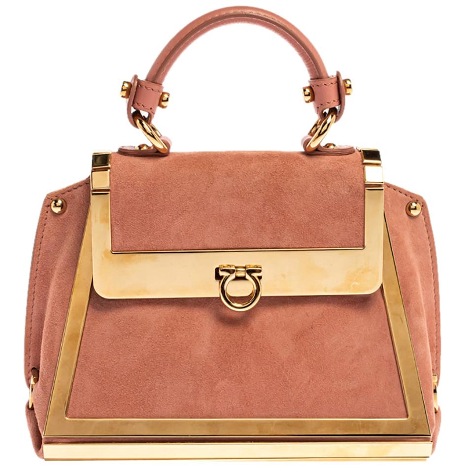 Carry this gorgeous Salvatore Ferragamo creation wherever you go and make people drool. Meticulously crafted in Italy and made from quality suede & gold-tone metal, this Sofia bag comes in a lovely shade of pink. It has been styled with a top