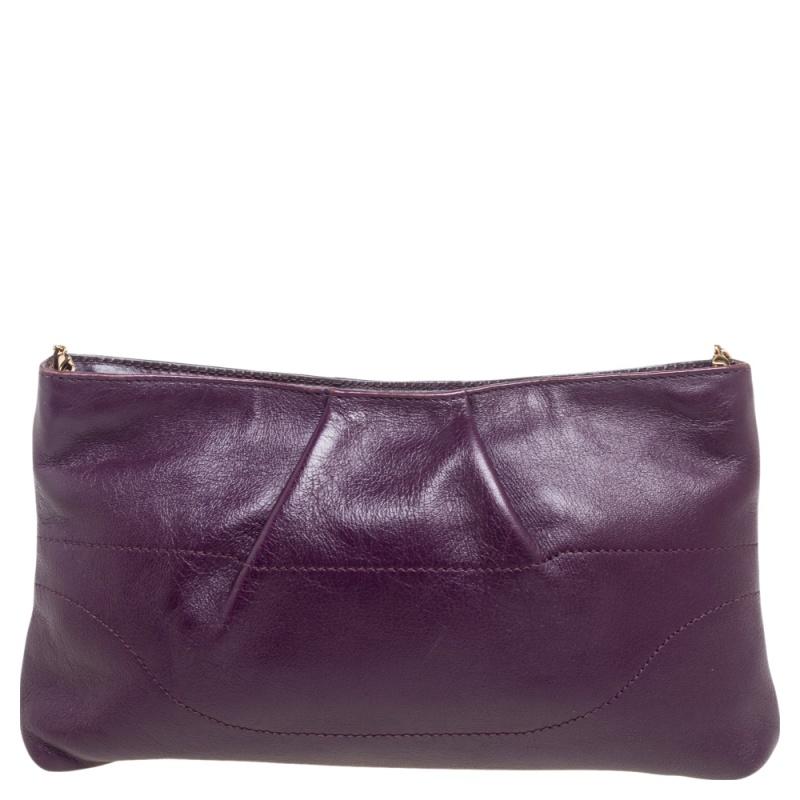 This purple flap bag from the house of Salvatore Ferragamo is lovely. It is crafted from leather and designed with a shoulder chain and the Gancini logo on the front. Suitable for both a party look and an everyday look, this chic bag is worth