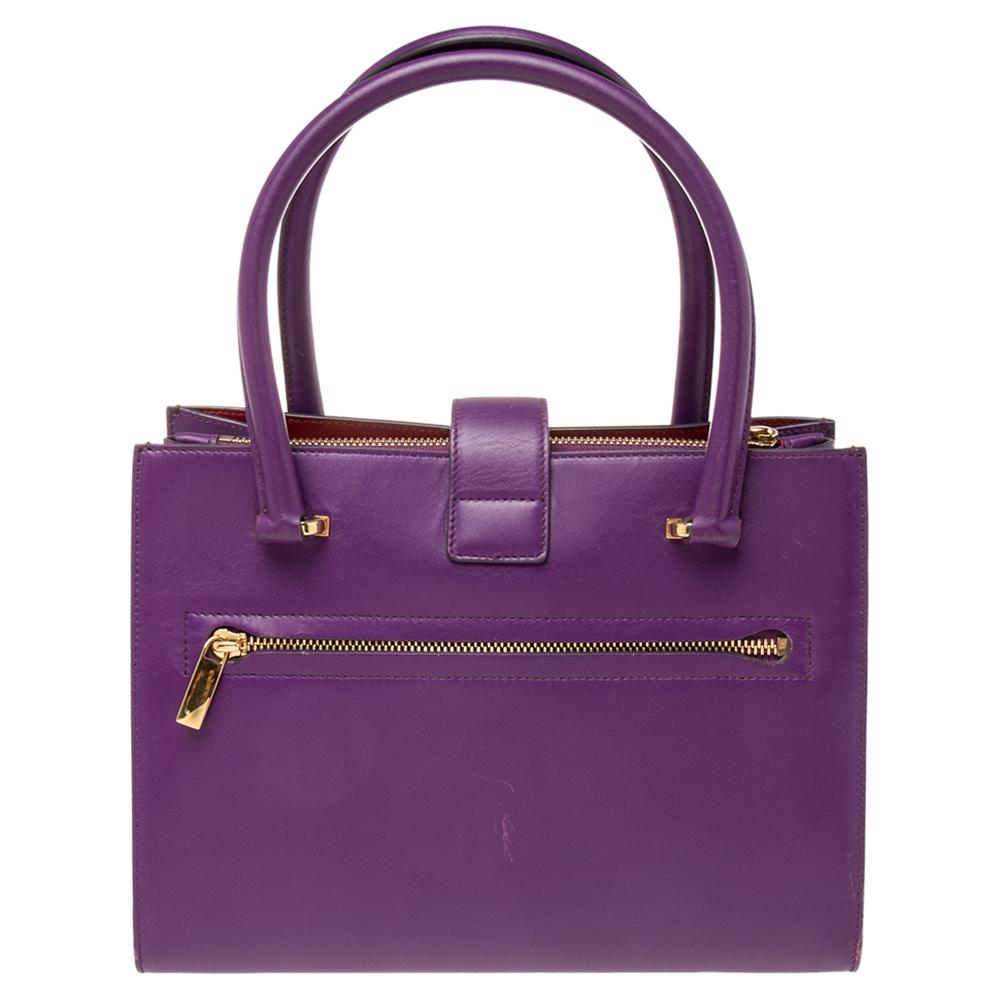 Simply sophisticated, this bag from Salvatore Ferragamo makes a signature statement. The exterior of this tote is crafted using purple leather with a gold-toned Gancio lock closure added to the front. It features dual top handles and a roomy