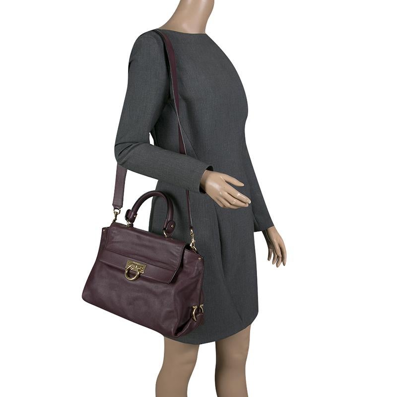 Go trendy with this purple bag, ideal for all your events, parties or outings. Meticulously crafted from leather, this Sofia satchel is equipped with a top handle, a removable shoulder strap, and protective metal feet. This stylish bag has a roomy