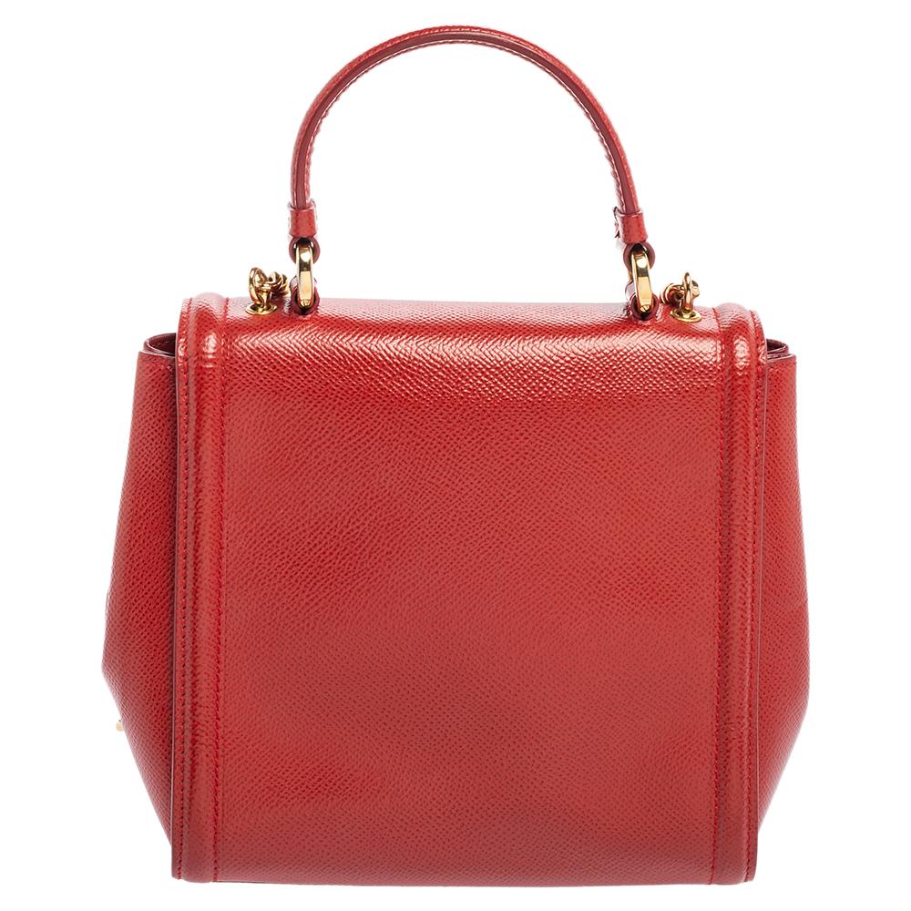 This bag from Salvatore Ferragamo has a refined and durable design. Made from red leather, it has been made convenient with a single handle, a chain-leather shoulder strap, and a leather-lined interior. The branded bow motif on the front gives the