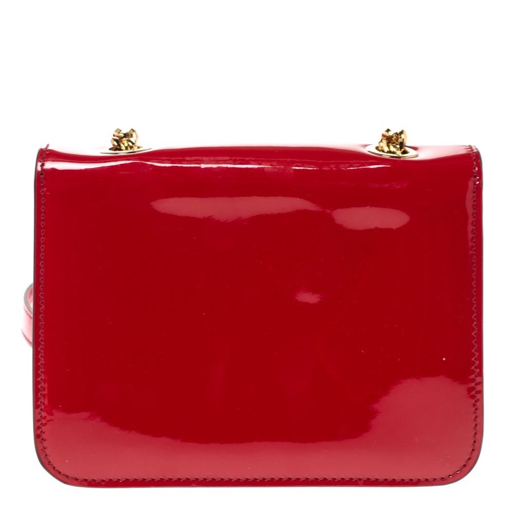 This pretty bag by Salvatore Ferragamo is perfect for lunches and outings with friends. Crafted from patent leather in a red shade, the bag has a chainlink strap for crossbody wear, gold-tone hardware, signature bow accent at the front flap, and