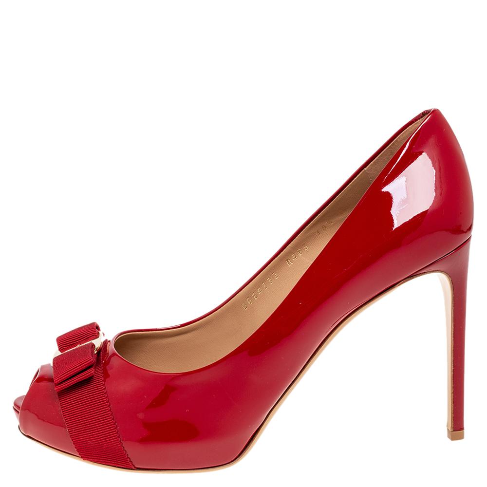The iconic Vara bow decorates the vamps of these timeless Salvatore Ferragamo pumps. Created in a red shade from glossy patent leather and styled with peep-toes and 11 cm heels, these pumps offer comfort with their leather-lined insoles. They are