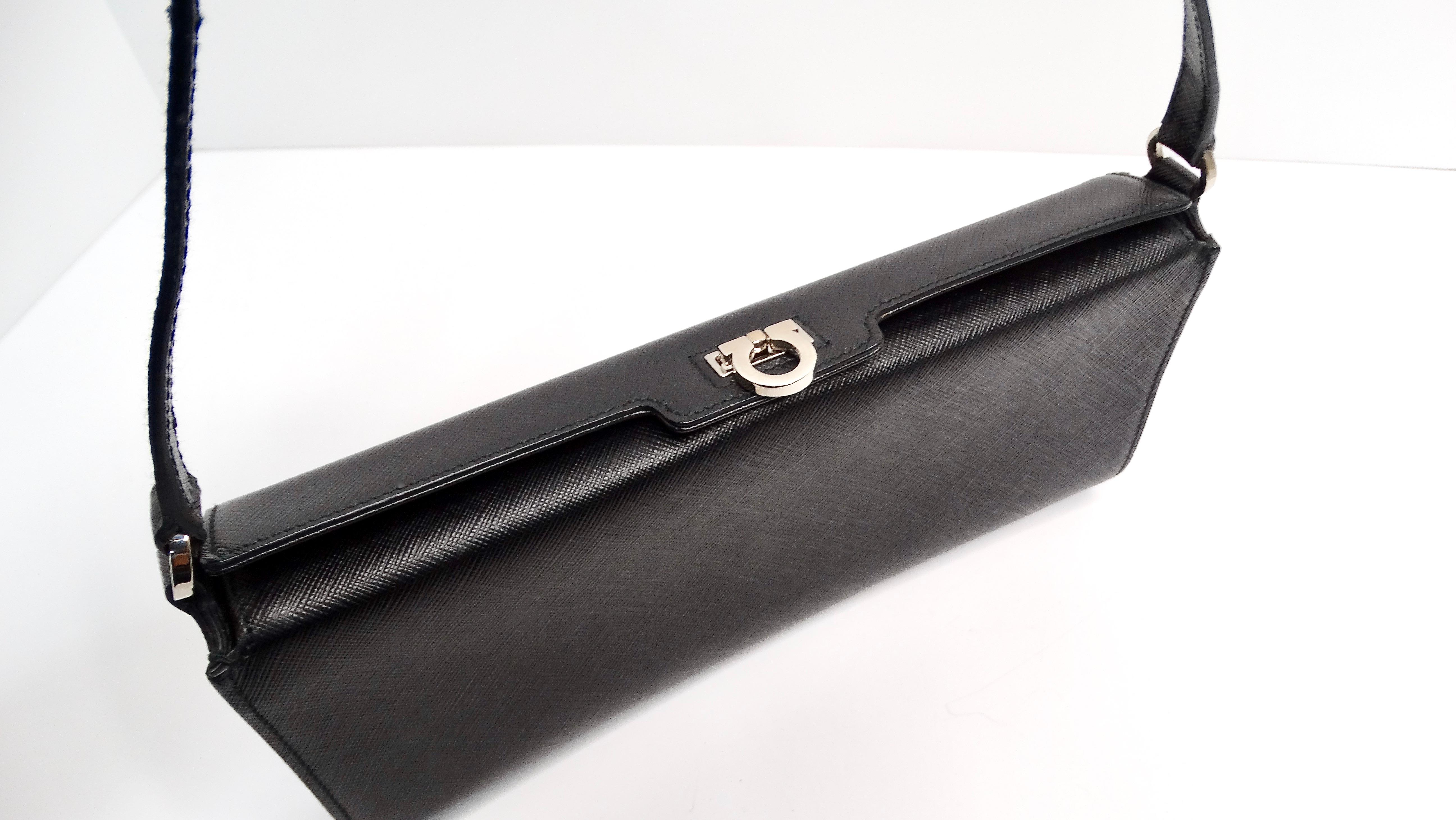 The Salvatore Ferragamo Saffiano Black Leather Shoulder Bag is a luxurious accessory that epitomizes sophistication and functionality. Crafted from high-quality pebbled calfskin leather in Italy, this structured shoulder bag radiates timeless