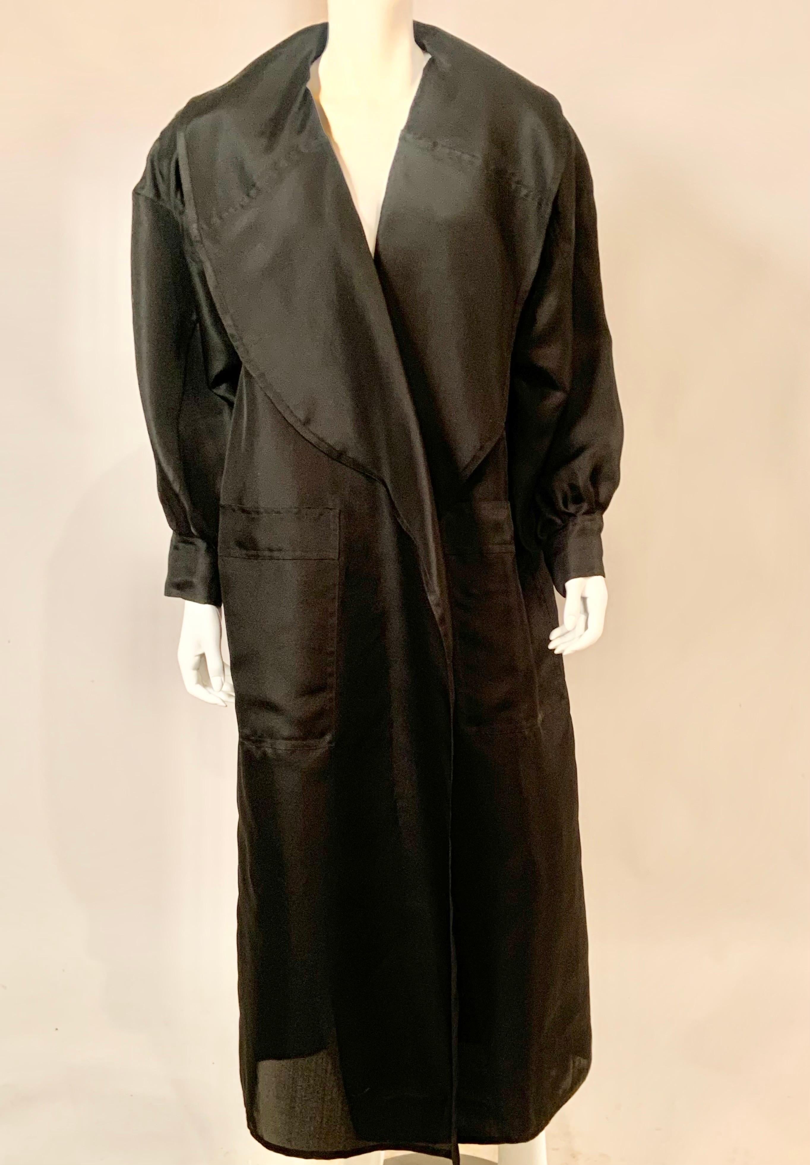 This voluminous sheer black silk duster coat from Salvatore Ferragamo is quite striking and definitely makes a statement.  The coat has oversized lapels, full sleeves with two button cuffs, one breast pocket and two extra large hip pockets.  There