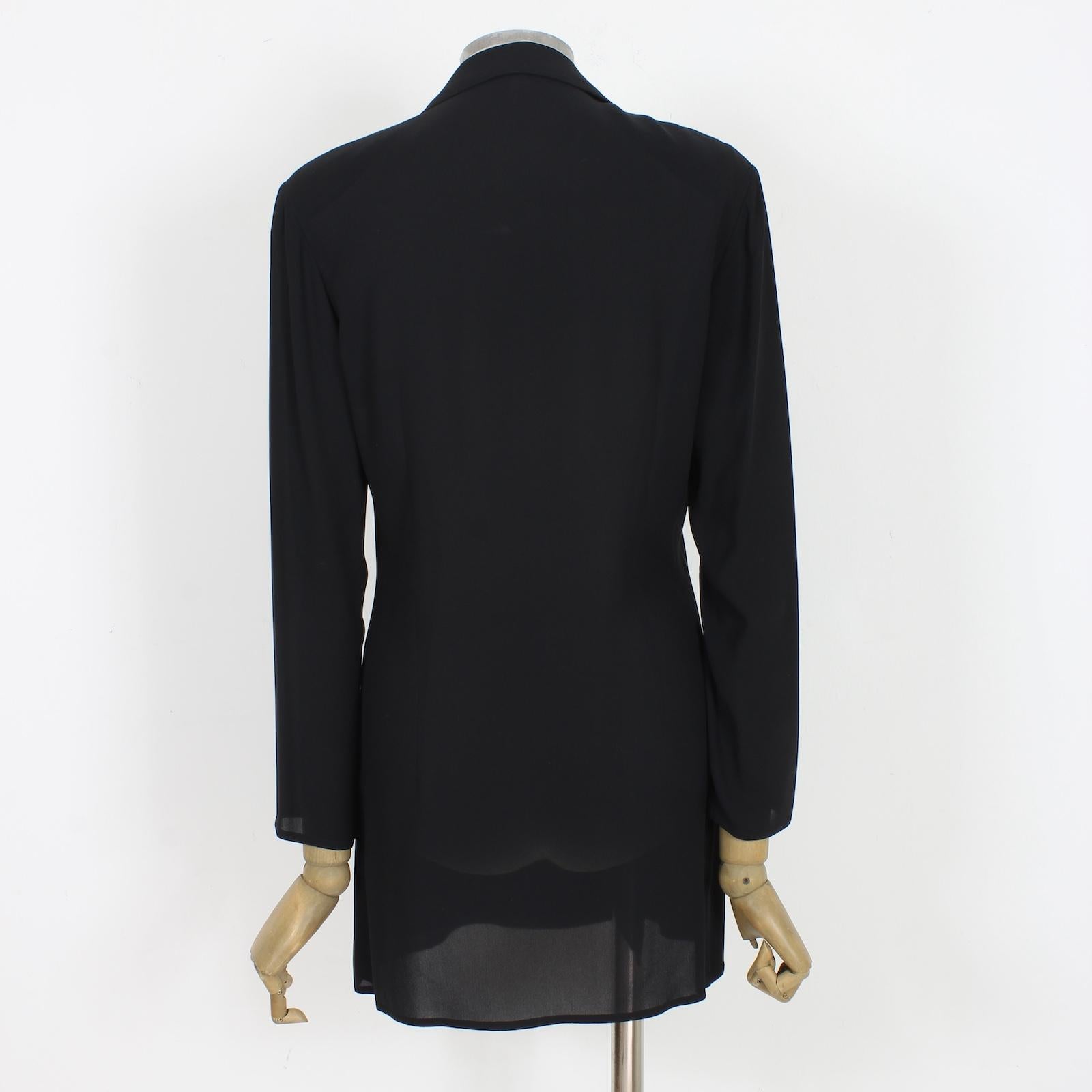 Expertly crafted by Salvatore Ferragamo, this vintage 90s black silk long blazer exudes elegance and sophistication. The double-breasted design, sheer and soft fabric, and padded shoulders add a touch of vintage charm. Elevate any outfit with this