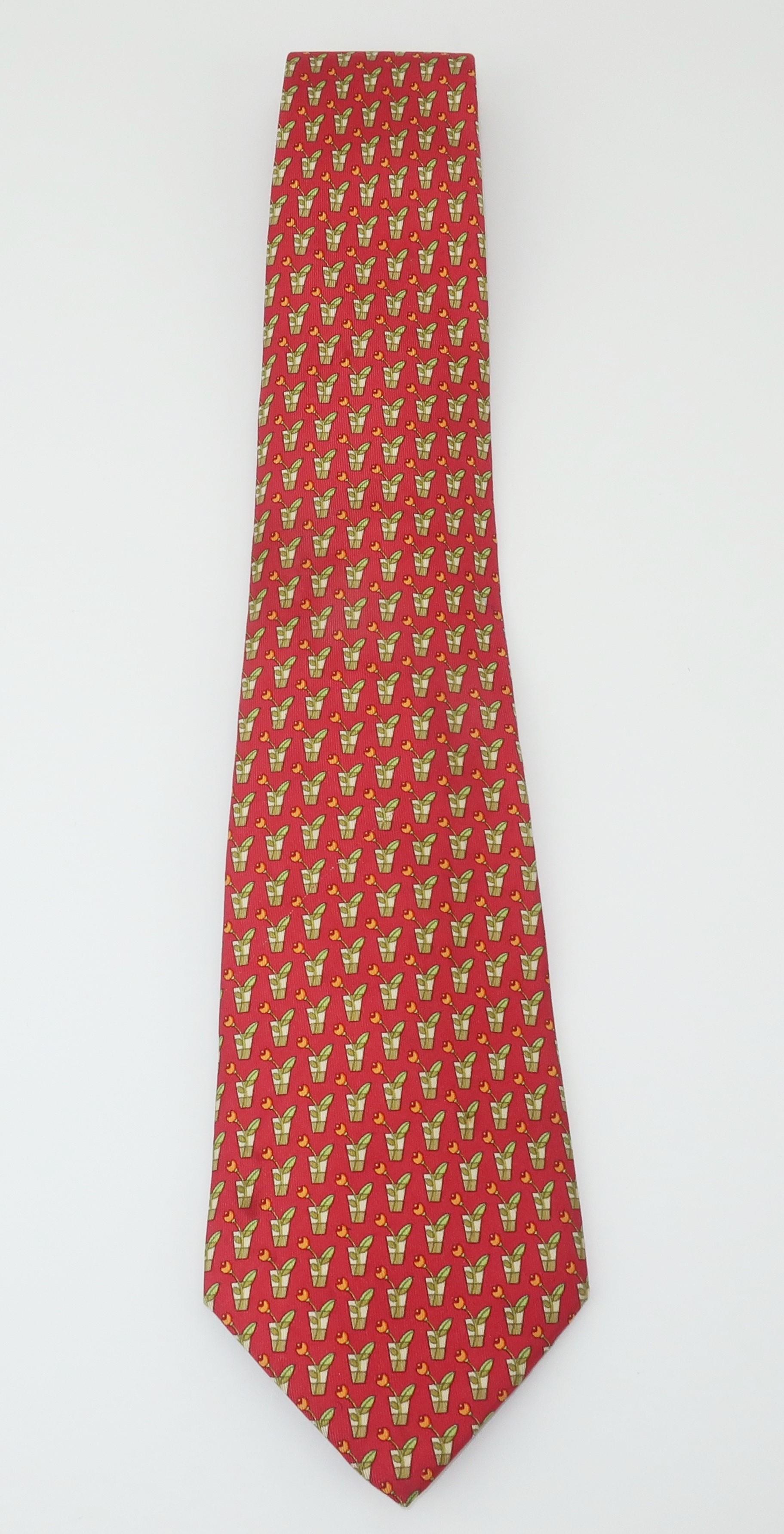 Ferragamo creates a menswear silk necktie with a cut flower motif in shades of watermelon red, sage green and light orange.  Beautifully made with the quality one would expect from Ferragamo.  Good to fair previously owned condition with a shadowy