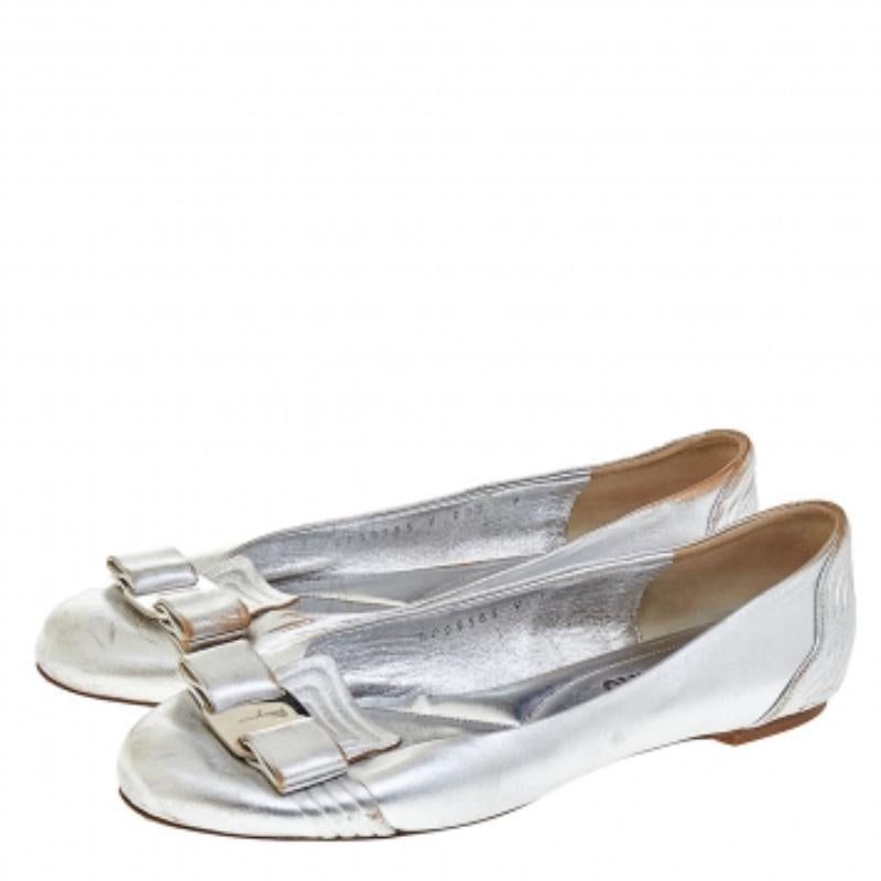 Queste impressionanti ballerine Vara Bow di Salvatore Ferragamo metteranno sicuramente in risalto il tuo look del giorno! La pelle argentata viene utilizzata per la realizzazione degli esterni, mentre le attrezzature argentate rifiniscono gli