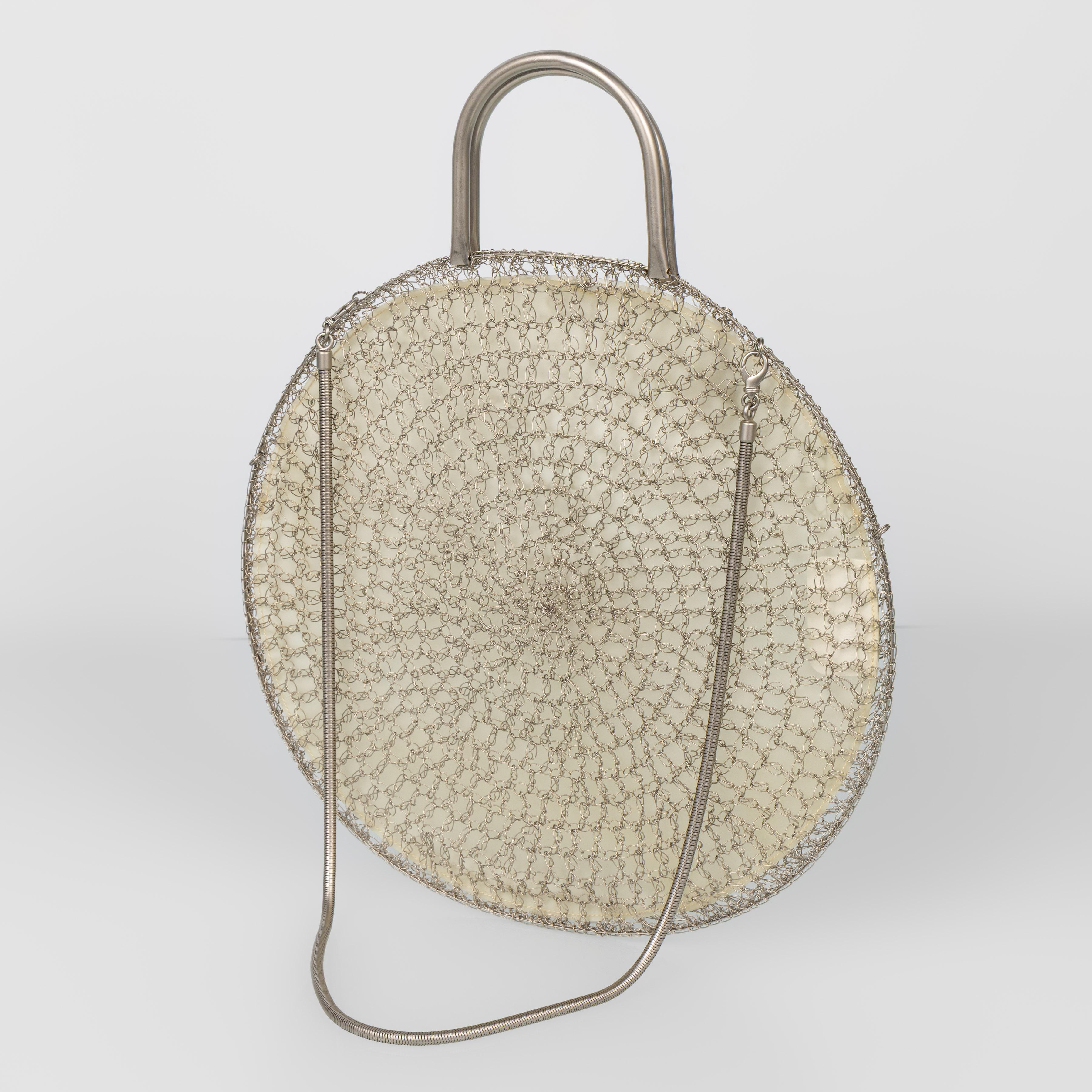 Scultorea borsetta rotonda di Salvatore Ferragamo realizzata in filo di metallo argentato lavorato a mano con un preciso intreccio a spirale. Questo sorprendente design degli anni '90 riflette l'esplorazione di Ferragamo della forma, della