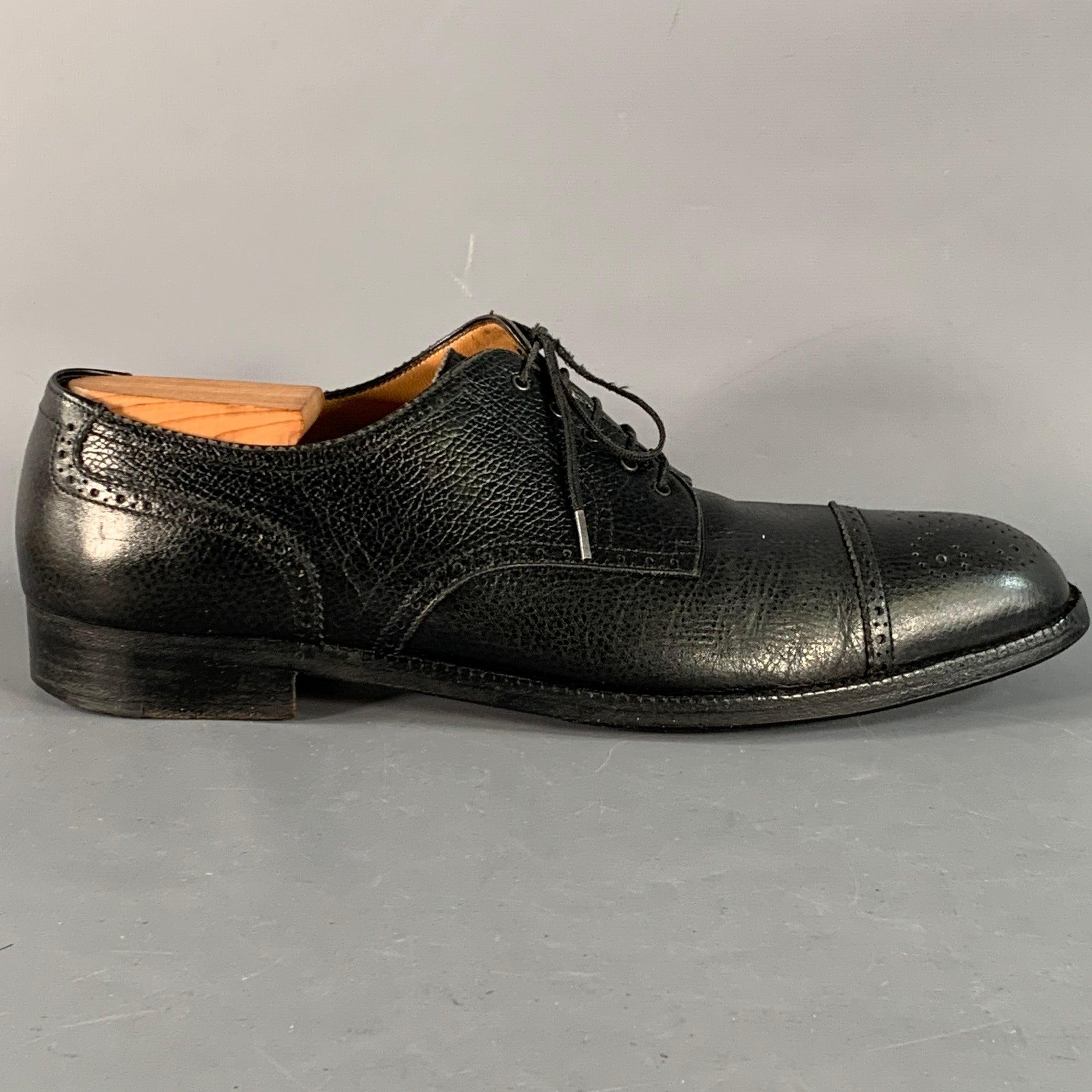 Chaussures derby SALVATORE FERRAGAMO en cuir grainé noir présentant un design perforé, un bout en forme de cap et une fermeture à lacets. Les embauchoirs ne sont pas inclus. Livré avec boîte. Remarque : ces chaussures ont été recouvertes d'un