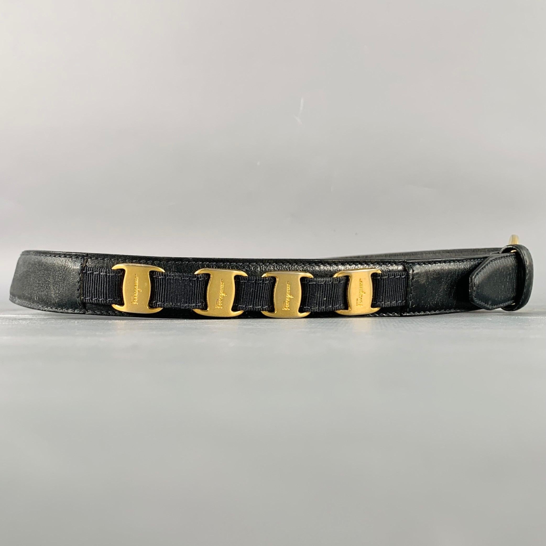 SALVATORE FERRAGAMO belt
in a black leather featuring gold tone metal logo details, and gold tone metal buckle closure. Made in Italy.Good Pre-Owned Condition. Moderate marks and signs of wear. 

Marked:   serial number fadedLength: 32.5 inches