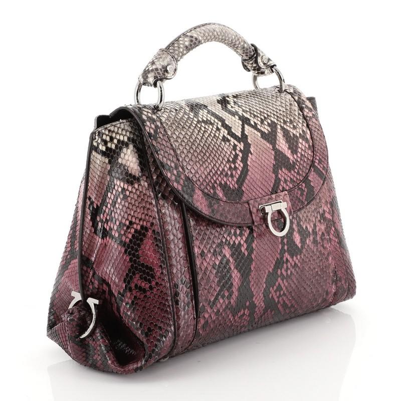 This Salvatore Ferragamo Sofia Satchel Python Small, crafted from genuine purple python skin, features a sturdy top handle, exterior back zip pocket, and silver-tone hardware. Its flip-lock Gancio closure opens to a brown leather interior with side